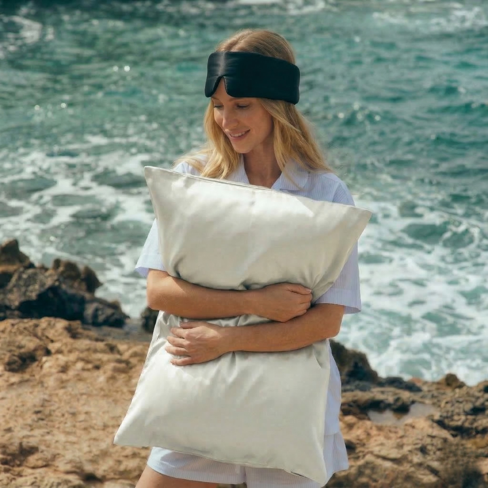 Woman holding GLOWE silk pillowcase in outdoors, lifestyle shot