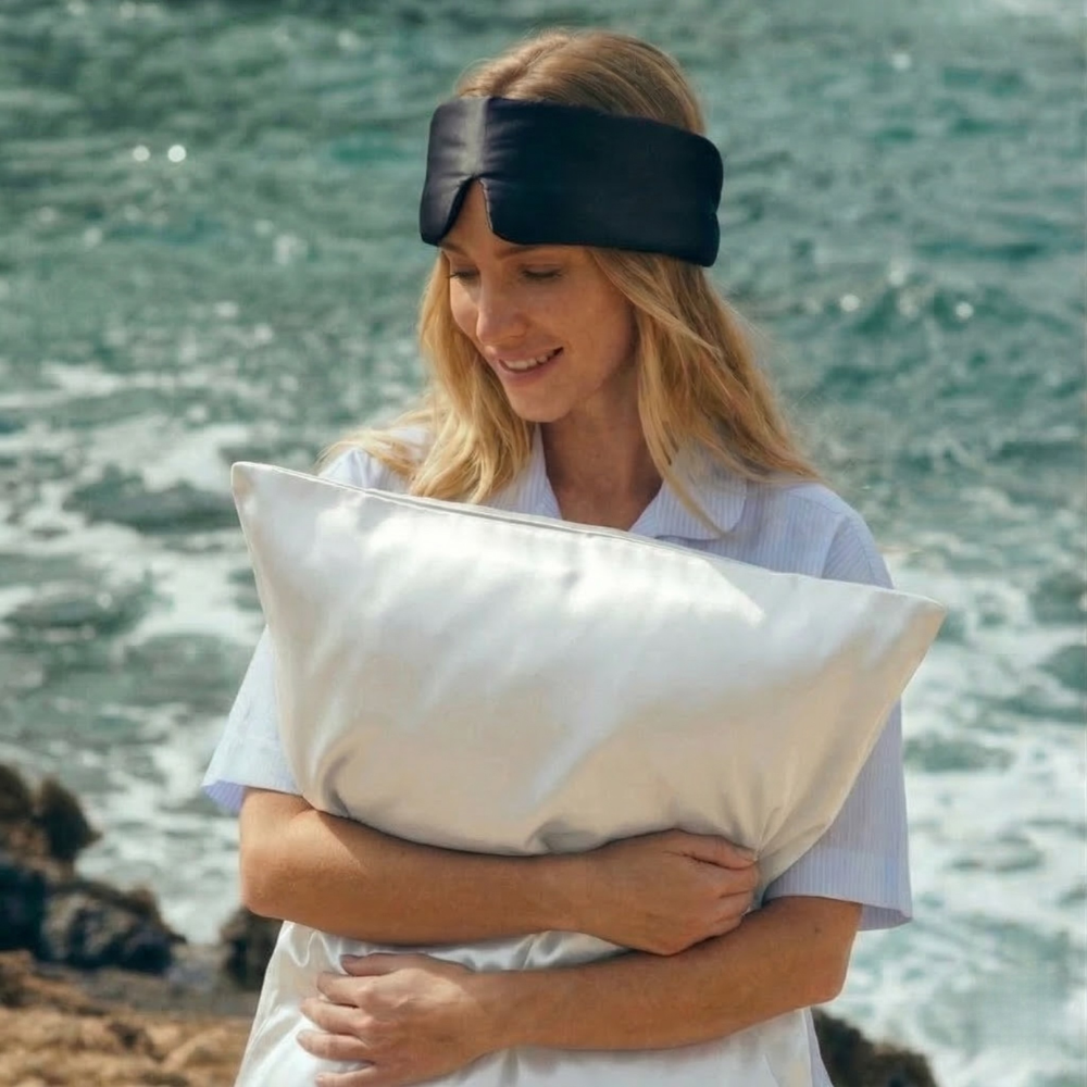 Woman holding GLOWE silk pillowcase outdoors, lifestyle shot