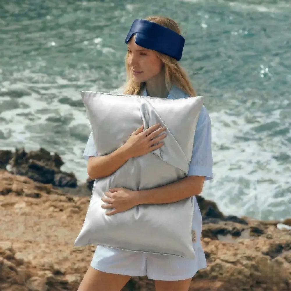 Woman holding GLOWE silk pillowcase outdoors, lifestyle shot