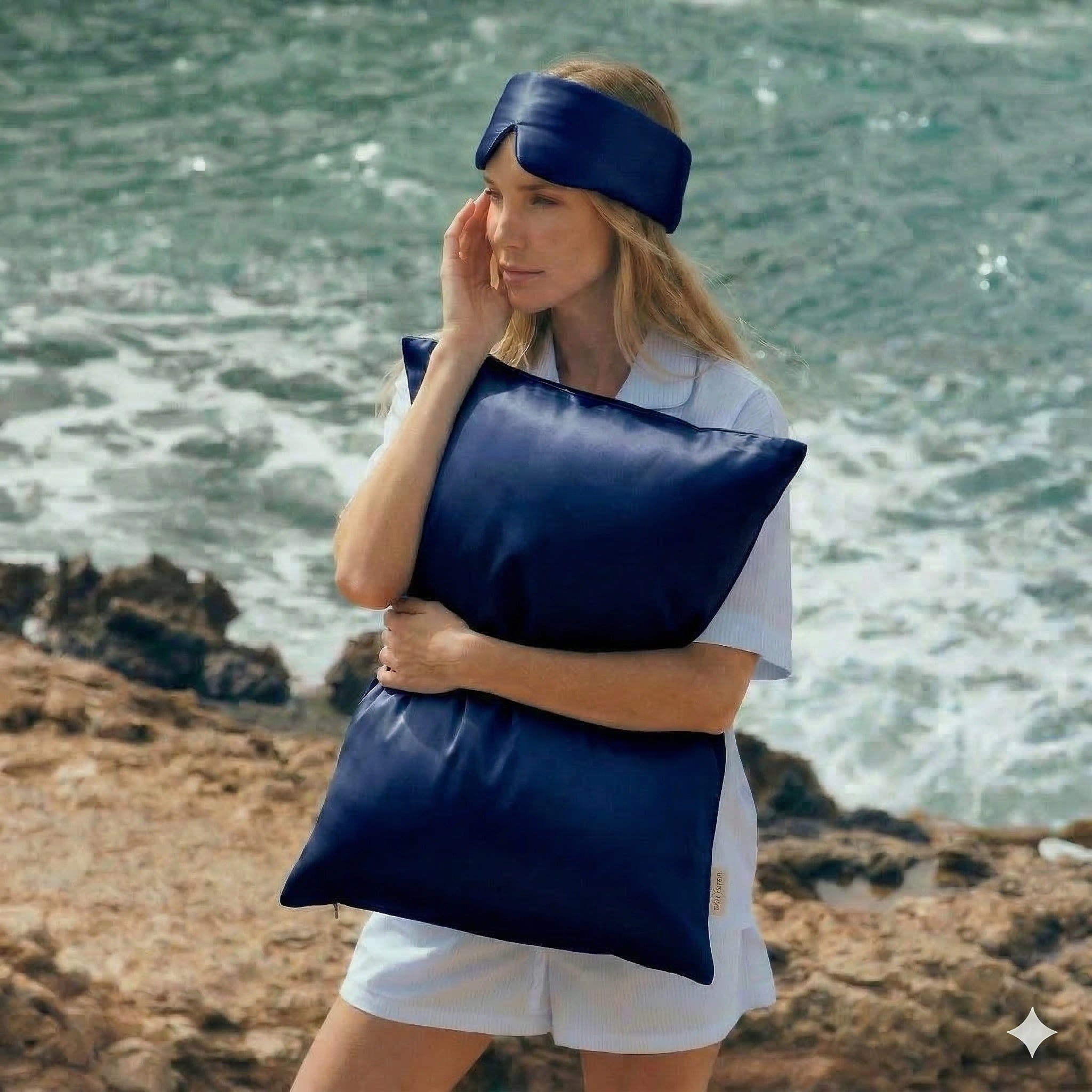Woman holding GLOWE silk pillowcase in Deep Navy outdoors, lifestyle shot