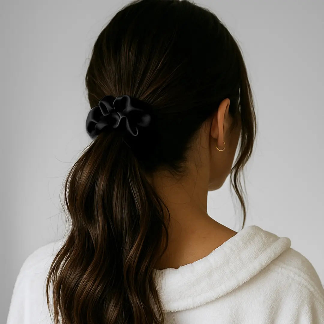Woman wearing GLOWE Silk Scrunchie in Midnight Black in ponytail, showing gentle hold without hair creasing