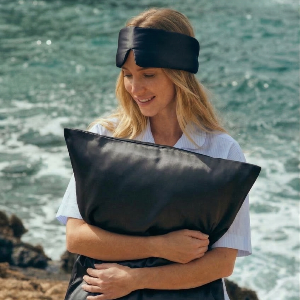 Woman holding GLOWE silk pillowcase in Slate Grey outdoors, lifestyle shot