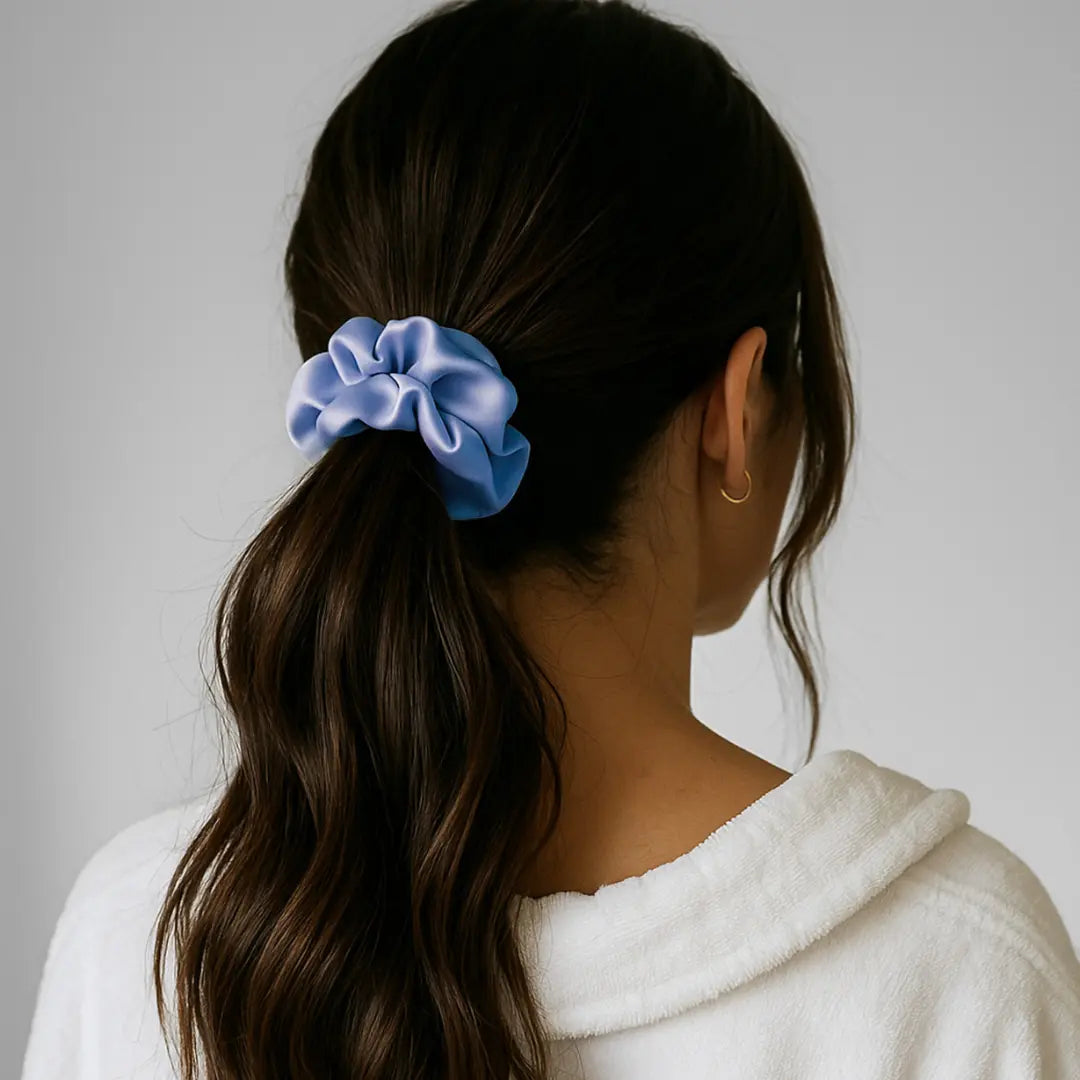 Woman wearing GLOWE Silk Scrunchie in Morning Blue in ponytail, showing gentle hold without hair creasing