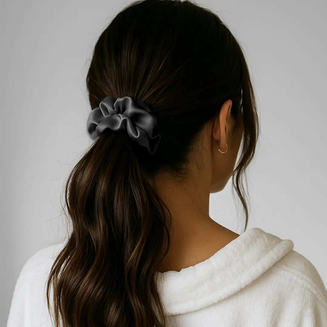 Woman wearing GLOWE Silk Scrunchie in Slate Grey in ponytail, showing gentle hold without hair creasing
